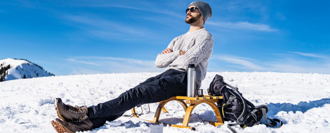 man in chair relaxing, while in the snow