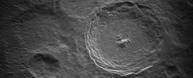 Greyscale image of large crater surrounded by other craters