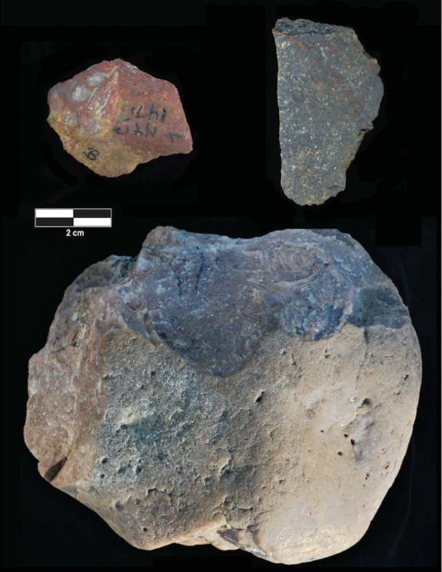 Three stone tools with sharp edges on black background