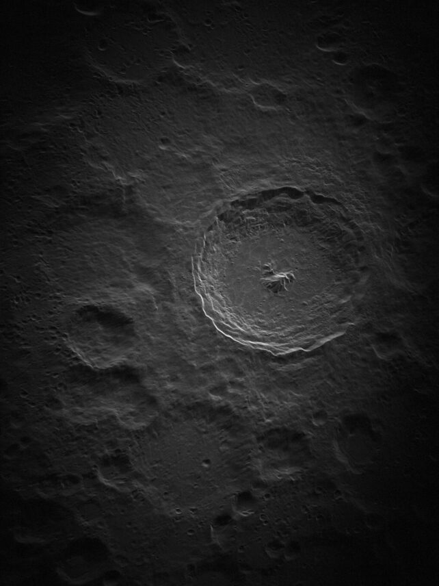 Greyscale image of big crater with hills in the middle