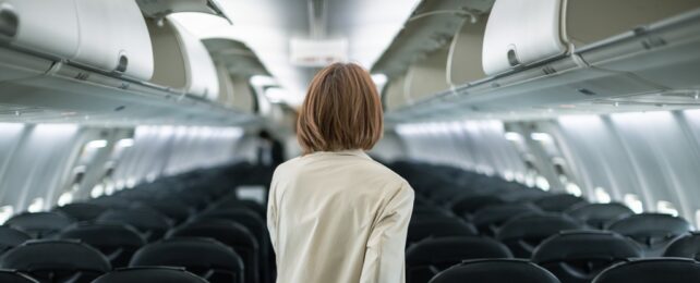 Woman Walks Down Empty Plane Aisle