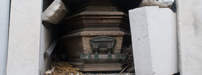 bricks of a tomb broken and moved aside to reveal the casket within