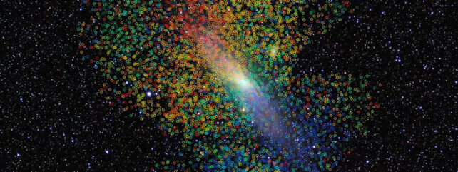 hundreds of tiny coloured circles superimposed on an image of andromeda