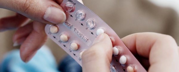 Contraceptive pill being popped out of fail sheet.