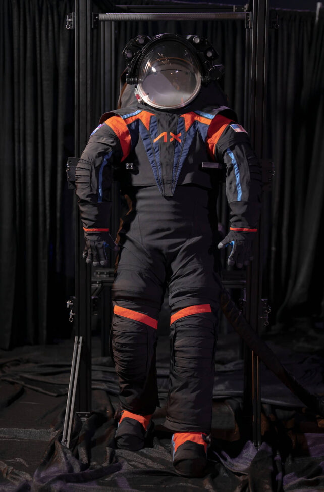 The spacesuit with a dark and orange accented cover.