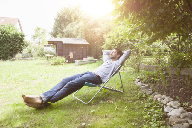 Man stretched out on chair with hand behind head