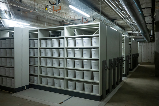 Movable shelves with numbered buckets containing human brains.