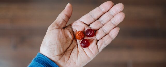 Hand Holding Gummy Supplements