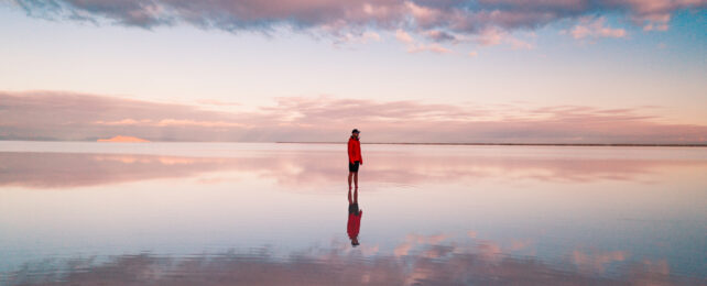 A man standing alone on the Bonneville salt flats.