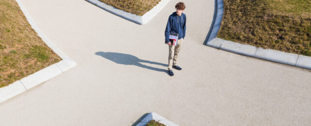 A man stands at a crossroads.