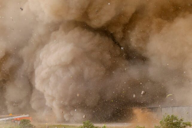 Brown clouds, rocks and other debris flung from launch site.