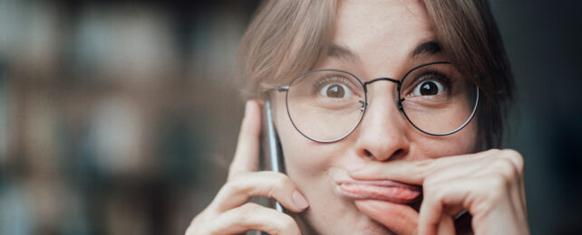 A woman presses her lips together with her fingers.