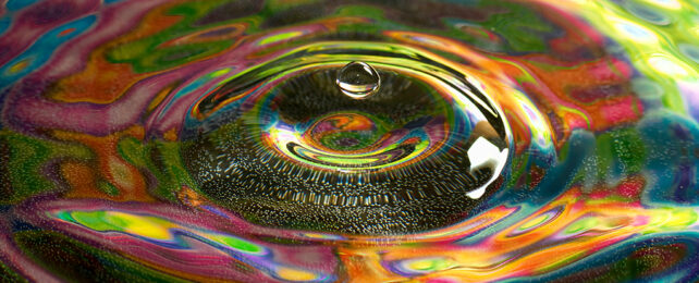 rainbow colours reflected in ripple on water surface