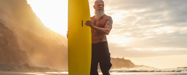 bearded man with a surf board