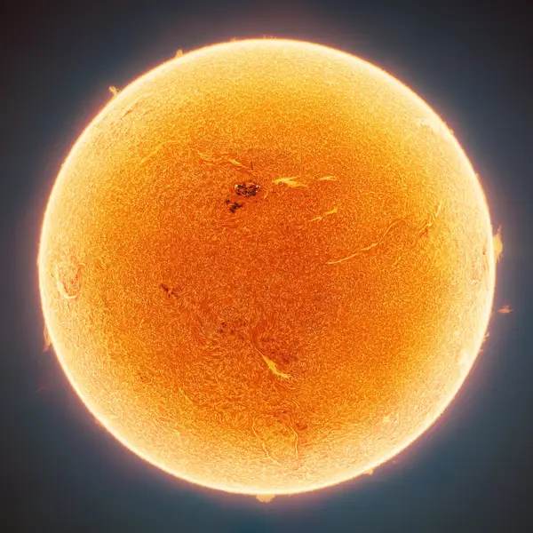 A close up of the sun with a small dark spot visible near the top left. 