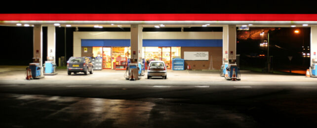 Service station with red-strip lighting illuminated at night.