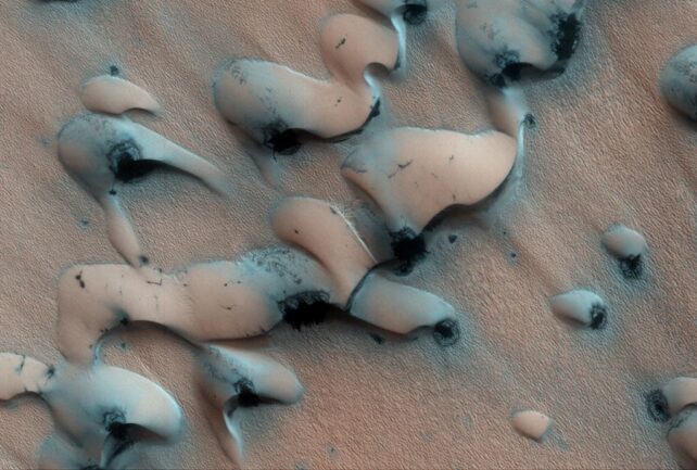Dunes on Mars, appearing as smooth raised areas on a rougher surface. 