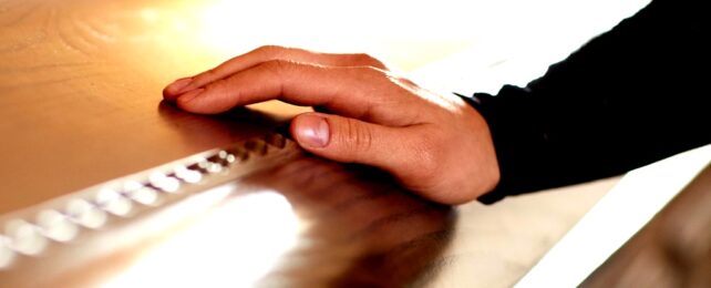 Hand On Coffin At Funeral