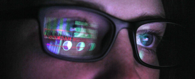 Person in glasses reflecting computer screen