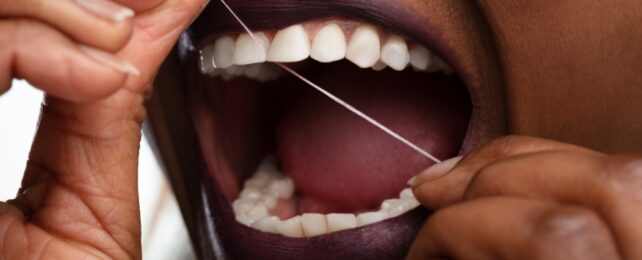 Close up image of dental floss and teeth