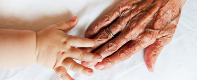young and old hand touching