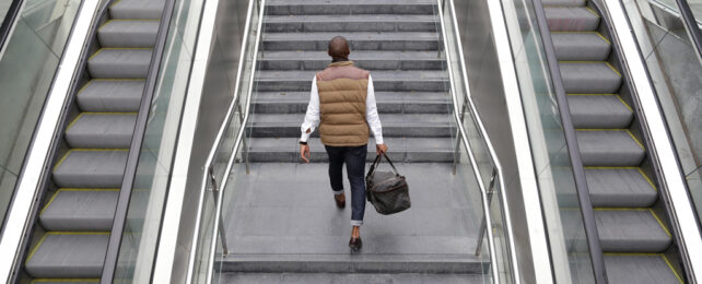 A person walking up stairs instead of using an escalator.