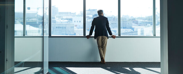 a man standing at a window looking out