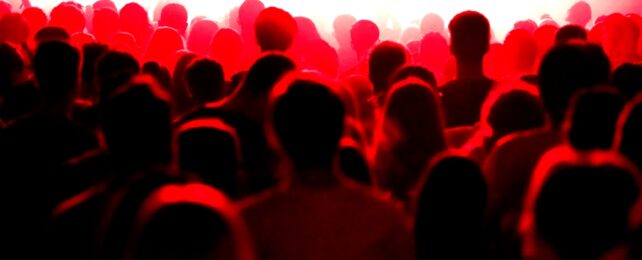 Bodies In Crowd Under Red Light