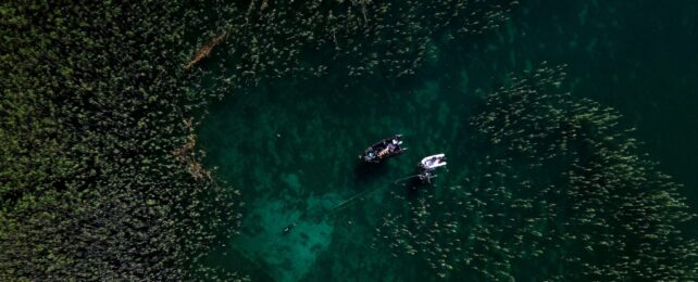 Divers With Boat In Lake