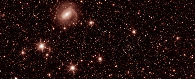 Close up showing red-tinged galaxies and stars