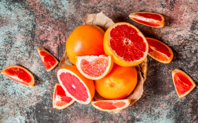Grapefruits on a stone bench, some of them cut in half or slices