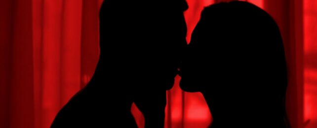 Man And Woman Kiss In Dark Bedroom