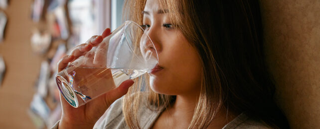 woman drinking water from a glass