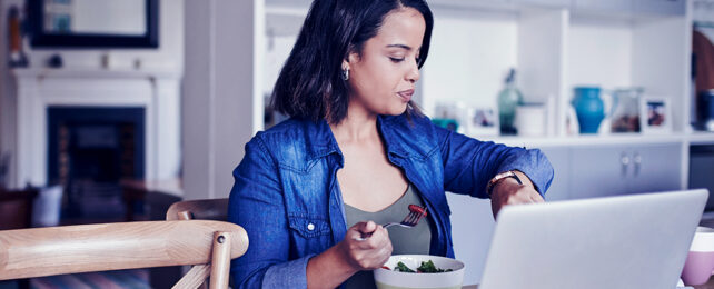 woman eating cereal while looking at her watch