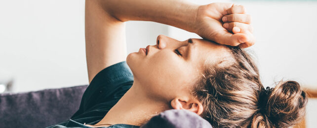 a women laying down with hand on head