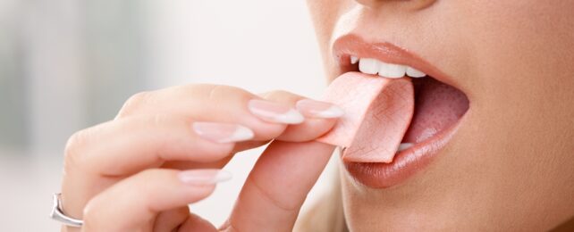 Hand Putting Chewing Gum Into Mouth