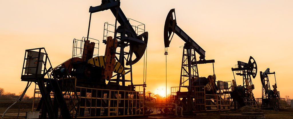 Oil rig pumping oil with a sunset in the background