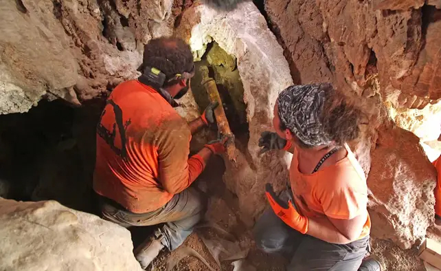 people recovering sword from cave