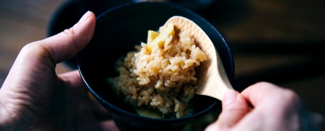 Hand Serves Rice From Bowl