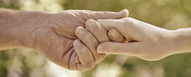 old hand holding young hand