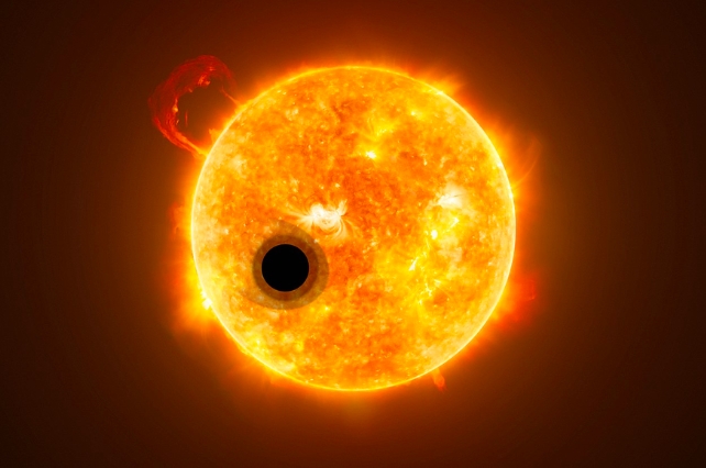 a bright yellow star with a dark planet in front of it