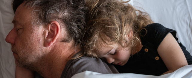 father and daughter asleep in bed