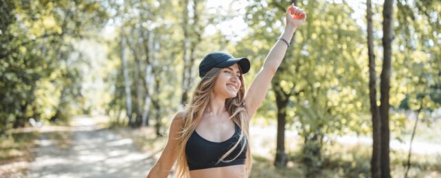 A person with long brown hair exercising outdoors