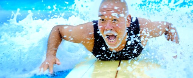 Man Smiles Riding Surfboard