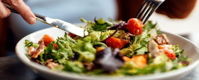 Person Eating Salad In Bowl