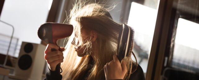 Young Woman Dries and Brushes Hair