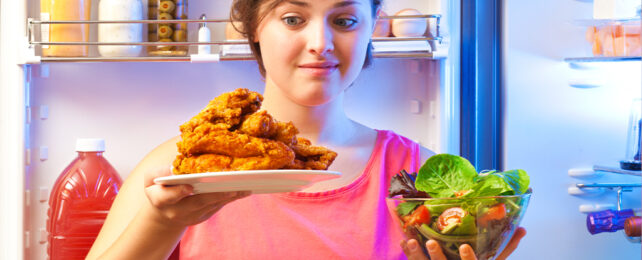 woman choosing between salad and chicken