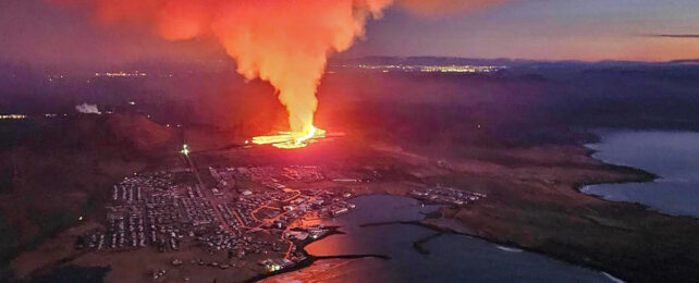 Aerial shot of larva flowing above evacuated icelanding town Grindavik