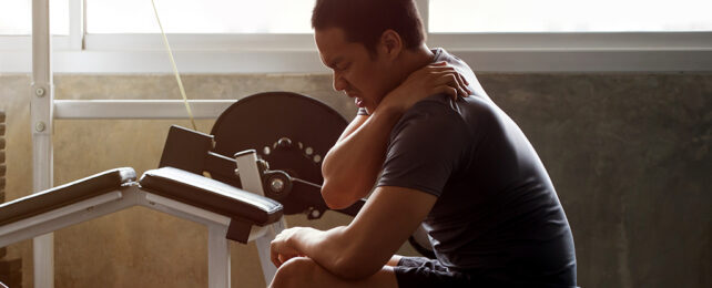 man in a gym clutching his shoulder