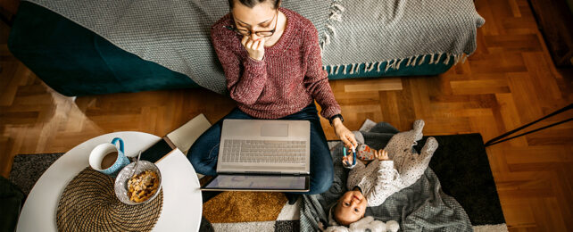 woman multitasking with computer and baby